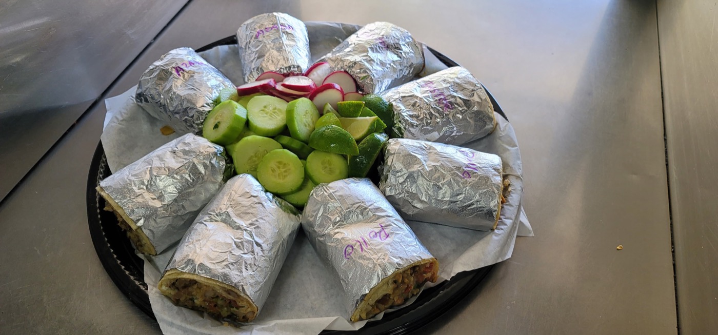 Catering platter of labeled burritos: asada, pastor and pollo