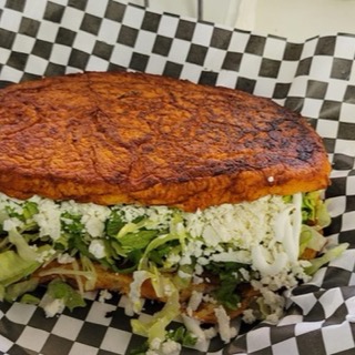 Pambazo, bread dipped in red guajillo sauce with lettuce and cheese