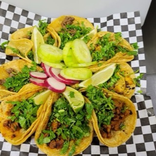 Street tacos topped with cilantro, onion, and lime at El Mini Taco
