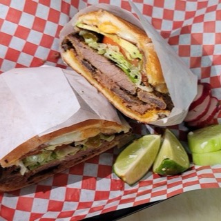 Torta with steak, avocado, lettuce and tomato on bolillo bread